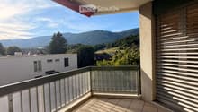 Balcony with tiled floor, glass railing, and scenic mountain view.