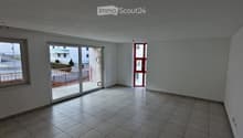 Empty room with tiled floor, white walls, large window, and sliding glass door leading to a balcony area.