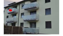 Four-story residential building with multiple balconies and modern railings.
