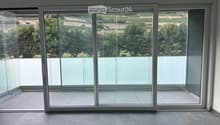 Empty room with large sliding glass doors leading to a balcony, tiled floor, and modern white frame.