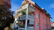 3 story house, red brick, white windows, balcony, plants