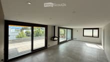 Empty room with tiled floor, large sliding glass doors leading to a balcony, and recessed ceiling lights.