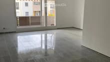 Empty room with dark tiled floor and large sliding glass doors leading to a balcony.