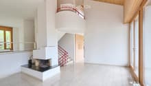 Bright hallway with a modern fireplace, wooden ceiling, large windows, and a red staircase leading to an upper level.