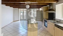 Bright, open kitchen with tiled flooring, wooden cabinets, stainless steel appliances, and a central island.