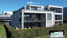 Modern multi-story house with a raised ground floor, two balconies, garden, and covered terrace.