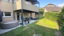Garden with a hot tub, outdoor seating area, and a covered balcony with a view of the house.
