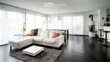 Modern living room with white sectional sofa, coffee table, fireplace, and large windows with blinds.