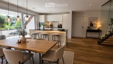 Open-plan living and dining area with modern furniture, pendant lights, and a sleek kitchen island.