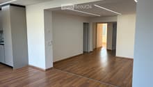 Empty room with wooden flooring, white walls, and recessed lighting. No furniture or equipment present.