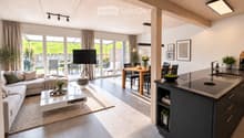 Open-plan living and dining area with a modern sofa, coffee table, dining table, and kitchen island. Large windows and sliding doors lead to an outdoor patio.