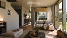 Modern living room with a light grey sectional sofa, coffee table, floor lamp, side table, mirror, bookshelf, and potted plants. The space features large windows and a view of an outdoor area.