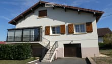 Two-story house with white exterior, wooden shutters, garage, and balcony accessible via stairs.
