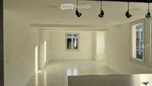 Empty room with white walls, tiled floor, and large windows. No furniture or equipment present.