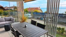 Balcony with a view of the sea, featuring a sofa, a dining table, and chairs.