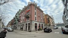 4-storey building with balconies on the upper floors, red walls with white details, multiple balconies