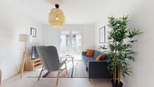 modern living room, open plan, glass doors, bright, wooden floor, colorful rug, grey couch, wooden chair, lamp, bamboo plant, TV