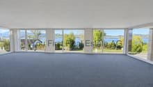 Helle Büroräulichkeiten mit Panoramafenstern und Seenblick