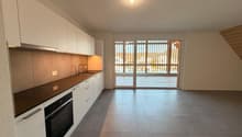 modern kitchen with white cabinets, wooden floors, gray countertops, built-in oven, sink with faucet, sliding glass doors to the terrace, white walls, recessed lighting