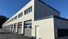 modern building, beige and gray exterior, multiple garages, windows, entrance door