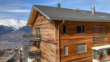 wooden exterior, multiple balconies, gray roof, mountain view