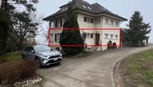 Two story house, white exterior, red roof, multiple windows, car parked in front, trees, grass