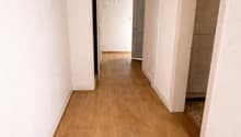 Empty hallway with wooden floor and white walls