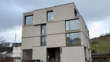 modern three story building, concrete, glass windows, raised ground floor, multiple balconies
