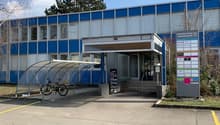 2-story commercial building with blue and gray exterior, covered entrance, and a bicycle rack outside.