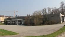 Warehouse building with three loading doors, signage on the wall