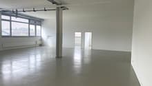 empty room, concrete floor, white walls, large windows, central column
