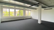 Empty room, white walls, black floor, large windows, central column
