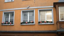 orange building, windows with white frames, holiday decorations on the windows, storefronts with window displays
