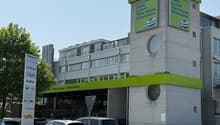 Steinmann Top building with Cafe, Lunch, Take Away Chocolate, multiple windows, cars parked in front
