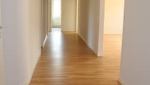 Empty hallway with wooden floors and white walls