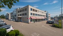 2 story commercial building, red awnings, large parking lot
