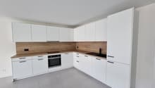 modern white kitchen with wooden countertops, white cabinets, grey tiled floor, gas stove, oven, and integrated appliances