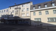 Three story building, white windows, red trims, entrance on street level