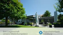Modern house with glass walls, terrace, garden, and outdoor seating area