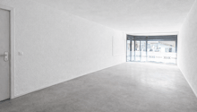 white walls, grey carpet, open door leading to outside, large windows