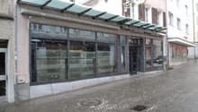 Facade of building with a canopy, glass windows, and signage.