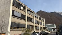 large modern building, parking, surrounded by mountains
