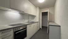 kitchen with integrated appliances and countertops, white cupboards and drawers, and a floor with tiles
