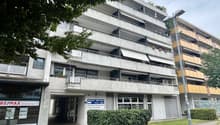 multi-story building, balconies, windows, air conditioners, entrance, sign