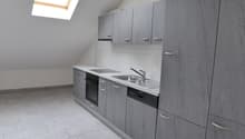 empty kitchen with light tile flooring, grey cabinets, stainless steel sink, dishwasher