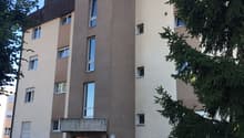 5 story building, red brick walls, glass windows, brown roofing, front entry