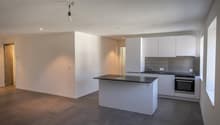 modern, minimalist kitchen with black countertop and white cabinets