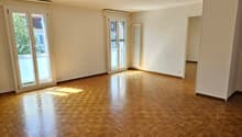 Empty room with double doors, large windows, wooden parquet floor, white walls