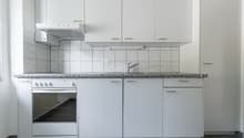 White cabinets, granite countertop, tiled backsplash, stove, dishwasher