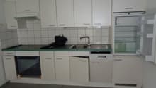 white cabinets, green countertop, stainless steel sink, dishwasher, refrigerator, oven, tiled walls